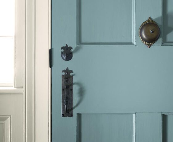 A light blue-painted paneled door with a traditional black handle.
