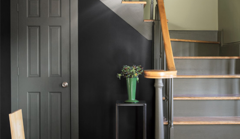 A dark blue-painted traditional entryway takes a twist with modern accents.