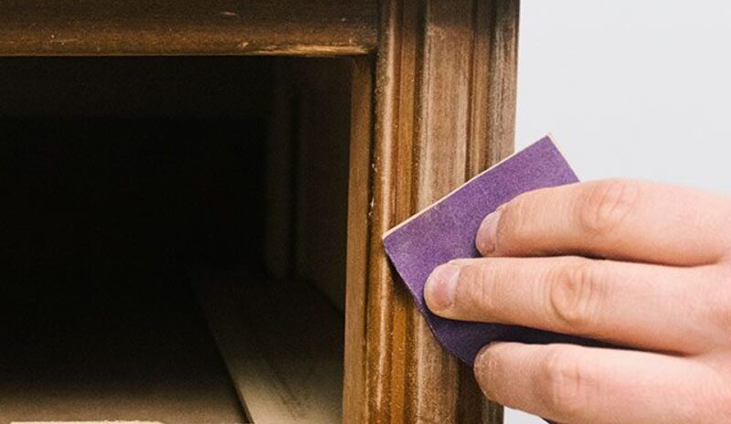 Raspar la superficie de madera con papel de lija.