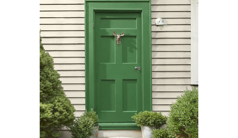 Revestimiento de casa pintado en un cálido greige, con una hermosa puerta verde