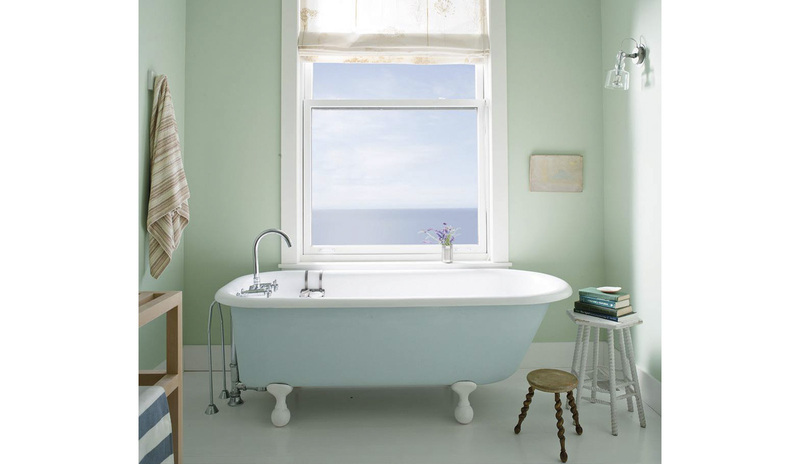 Un sereno baño verde claro Palladian Blue con una bañera con patas pintada de azul claro