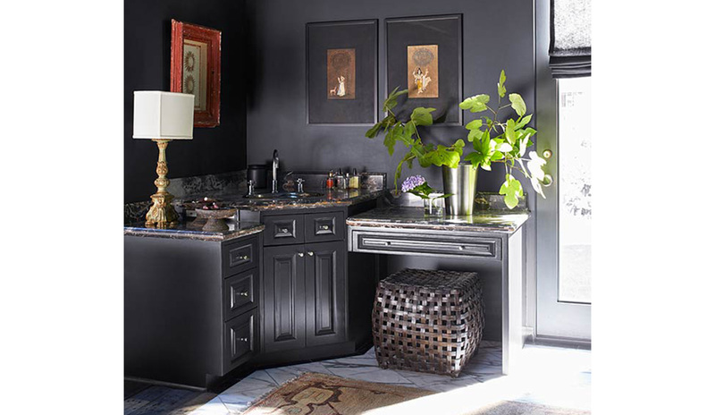 Una entrada de color gris oscuro con espejo, puerta con ventana grande y una mesa decorativa.