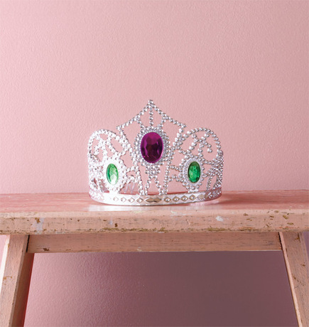 Una pared de tonos rosados resalta una tiara enjoyada.