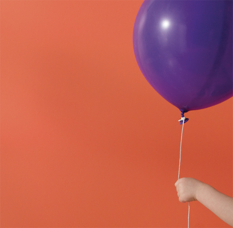 Una pared pintada de naranja enmarca un globo violeta.