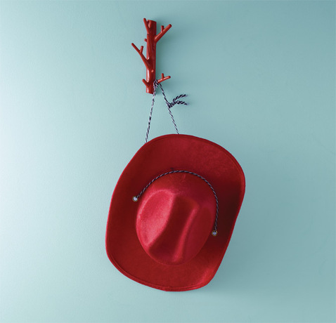 Una pared azul pálido enmarca un sombrero de vaquero rojo.